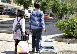 Una niña y un niño camino del colegio en una foto de archivo.