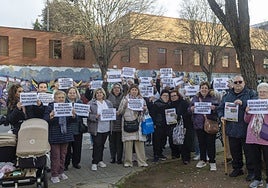 Un grupo de vecinos, con el presidente Ayuso, segundo por la derecha, muestra sus pancartas.