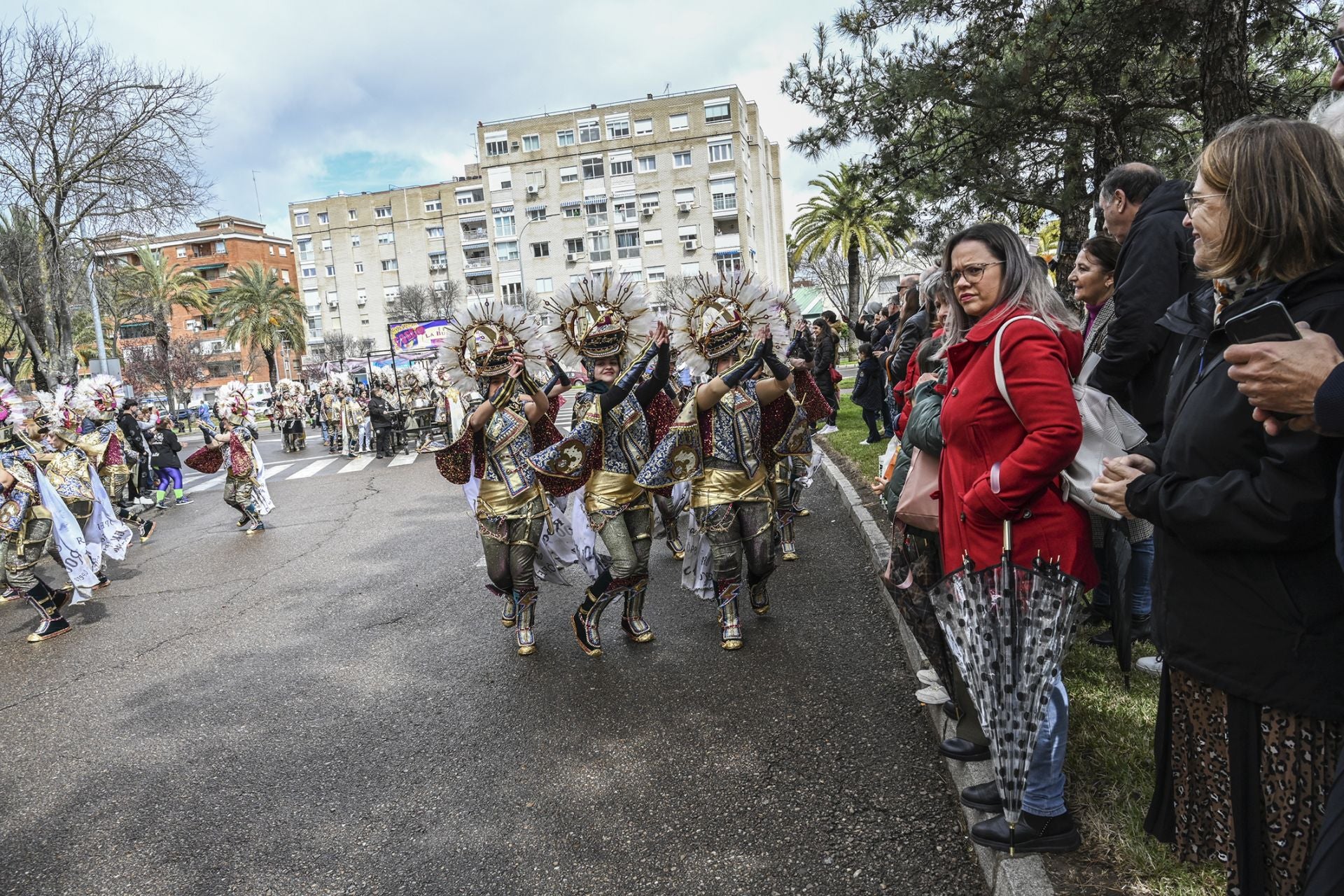 El público disfruta del desfile de comparsas de Valdepasillas con el paraguas en la mano