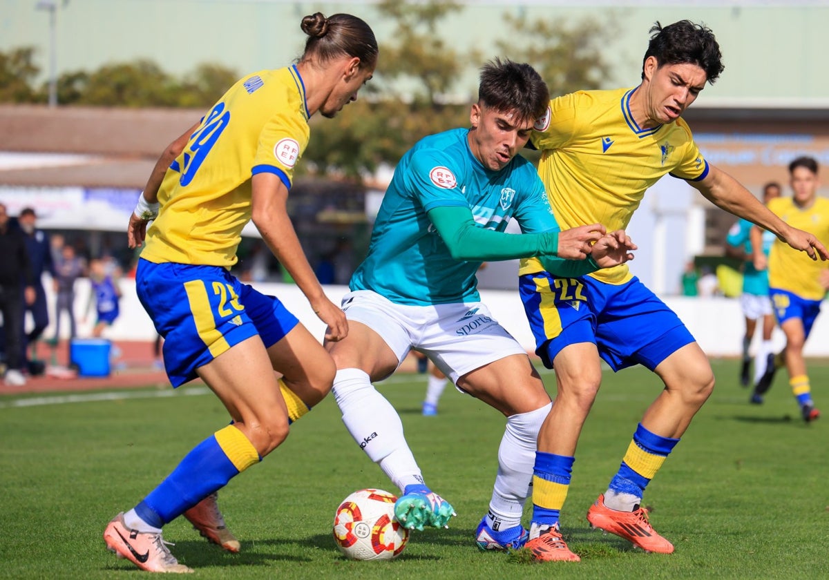 Óscar Muñoz, entre dos jugadores cadistas en la primera vuelta.