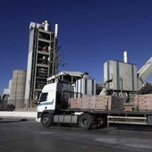 Un camión cargado de cemento pasa junto a la cementera de Alconera.