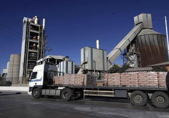 Un camión cargado de cemento pasa junto a la cementera de Alconera.