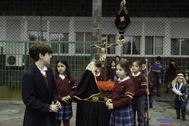 Los alumnos de primera portan la imagen que homenajea a la hermandad de la Estación.