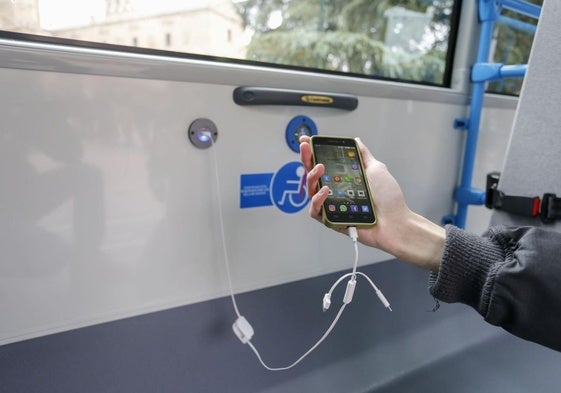 Un usuario carga un móvil en un autobús.