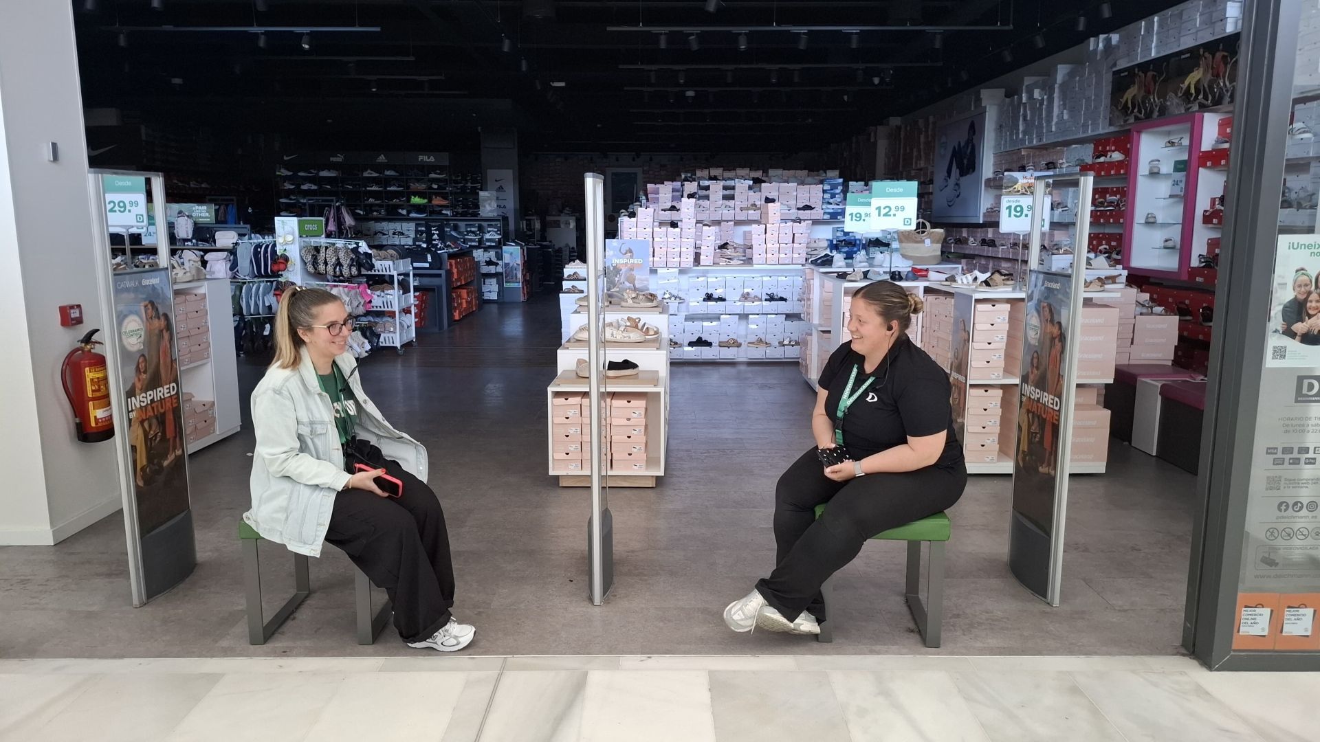 Trabajadoras de una tienda del centro comercial El Faro de Badajoz, en la puerta, con el establecimiento a oscuras.
