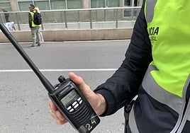 Un agente muestra uno de los 'talkies' antiguos, con cinta adhesiva para que no se salga la batería.