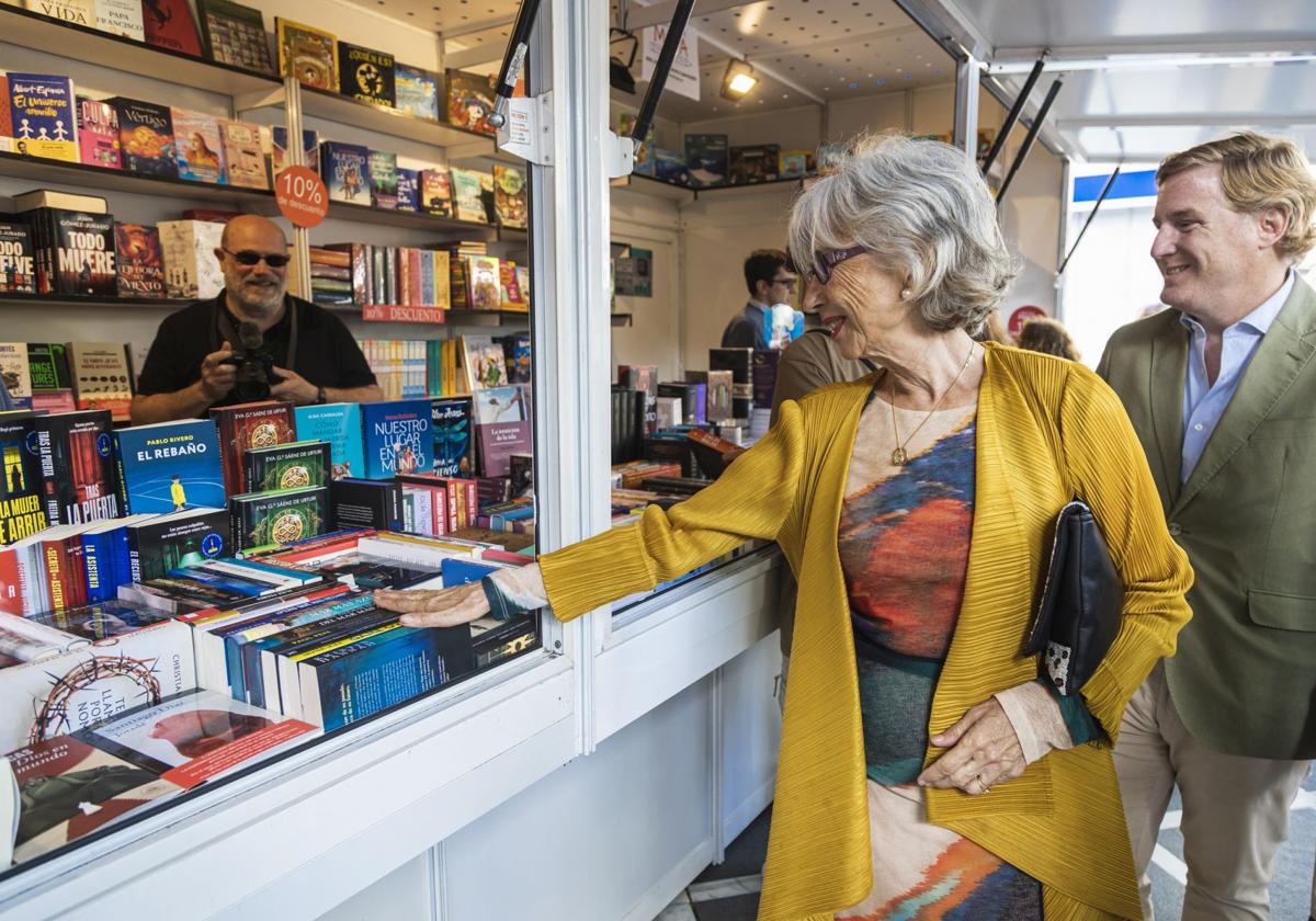 Pilar del Río e Ignacio Gragera miran libros en una caseta de la Feria del Libro de Badajoz, este viernes.