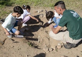 Un alumno trabajador de Barraeca enseñando los tipos de enterramientos a los escolares.