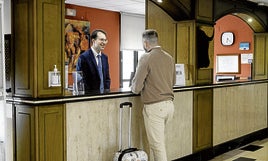 Un huésped registra su llegada a la recepción del hotel Río.