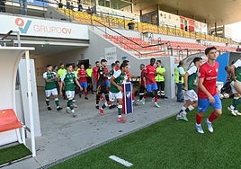 Los jugadores del Cacereño y Estepona saltan al terreno de juego este lunes en la reanudación del partido suspendido el día anterior.