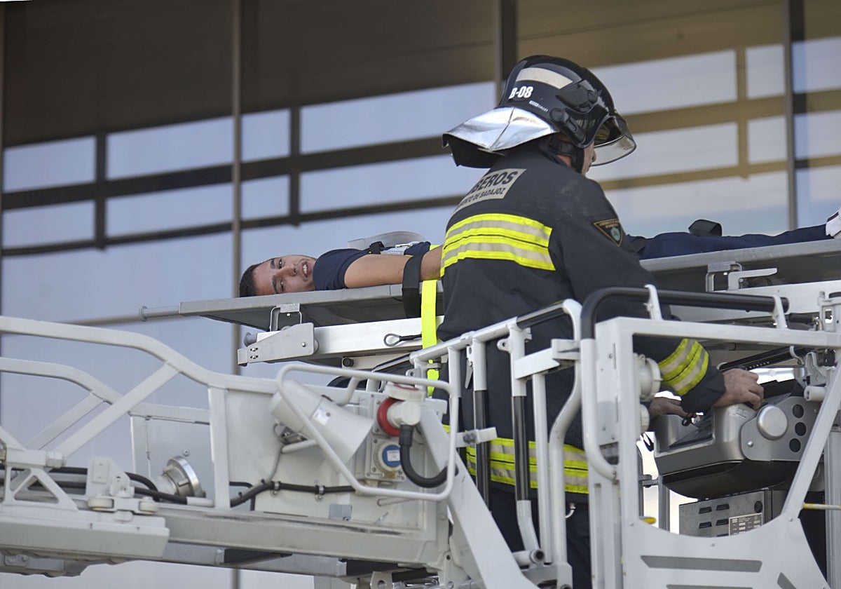 Un bombero ancla a la autoescala una camilla con una persona durante un simulacro de incendio en la torre Siglo XXI.