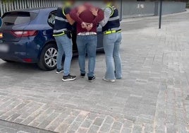 Agentes de la Policía Nacional introducen en el vehículo a uno de los detenidos.