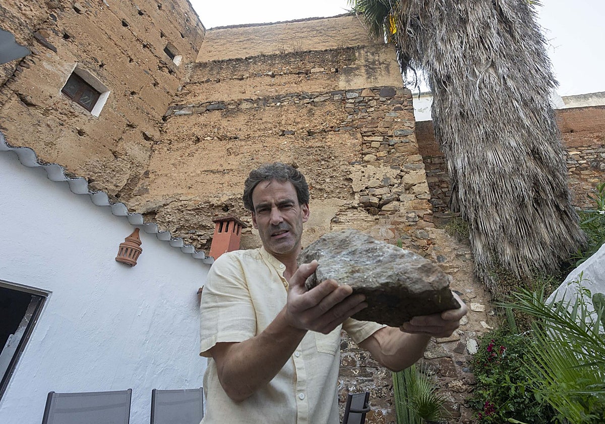 Rodrigo Albarrán, dueño de la casa que linda con la Torre de Caleros, muestra una de las piedras de la construcción que han caído a su patio.