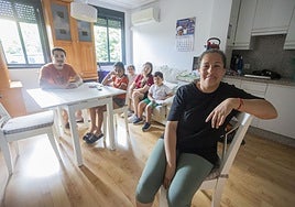 Fátima, en primer plano, junto a sus cuatro hijos y su hermano, Carlos Alberto, en la vivienda que comparte en la calle Miralrío de Cáceres. En la foto falta el marido de Fátima, que también reside en este piso.