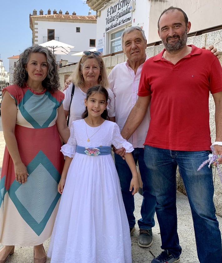 Imagen secundaria 2 - Los pequeños recogen pétalos ante el altar. En Santa María la procesión y las enseñas de las cofradías se encontraron con el material del festival de teatro. María Reyes Torres, de nueve años, posa con sus padres y abuelos en la Plaza Mayor de Cáceres.