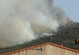 Un helicóptero se dirige a las llamas en Oliva de Mérida.