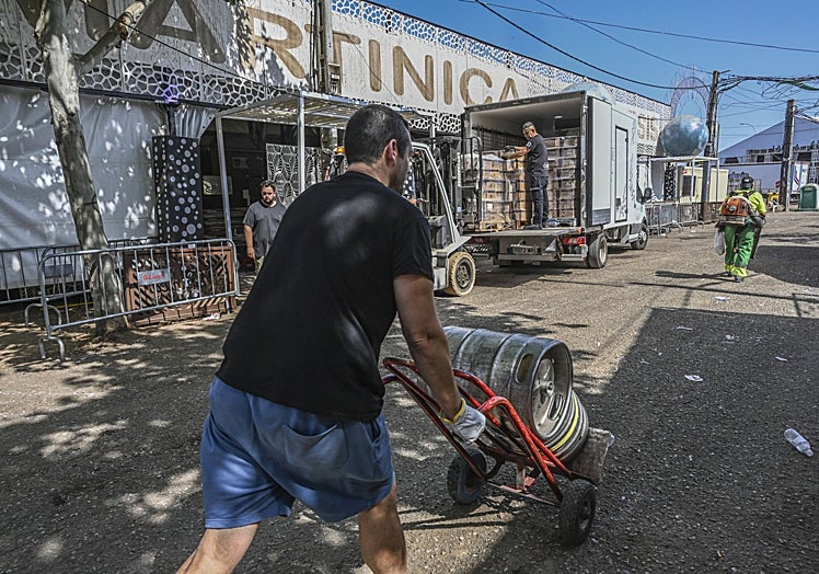 Los operarios vacían de bebidas las casetas este domingo por la mañana.