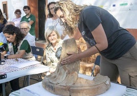 Una trabajadora de la campaña de excavación junto al pie del altar de mármol descubierto en el Turuñuelo. Al lado, Bazaga, Rodríguez y Celestino.