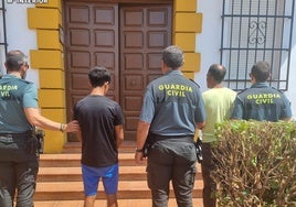 Los dos detenidos son custodiados por agentes de la Guardia Civil.
