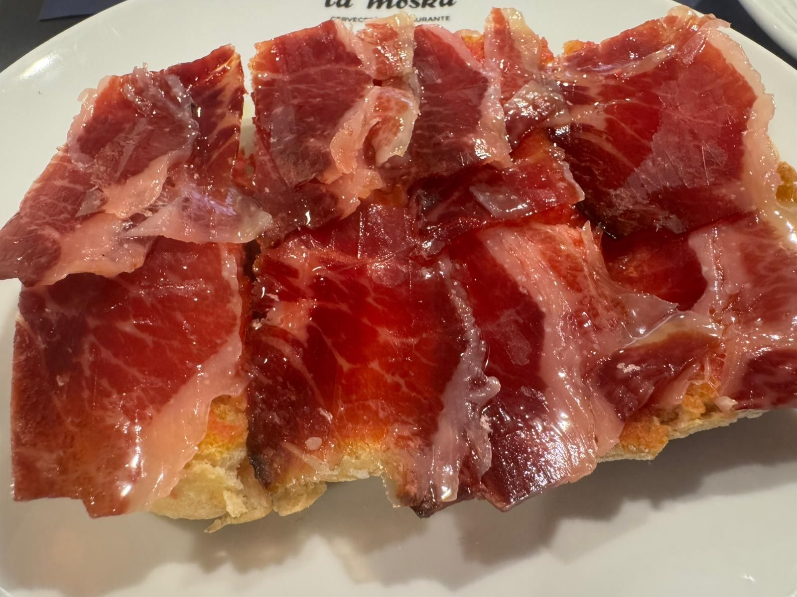 Un bollo artesano de Alburquerque, tomates de verdad de Villafranca del Guadiana, AOVE 100x100 local. Y como no, un jamón de cebo de campo de la tierra. No nos podemos olvidar de un buen café 100x100 natural Delta.