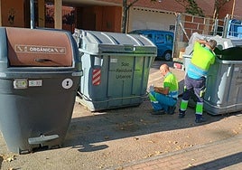 Operarios de valoriza cambiando las tapas de los contenedores.