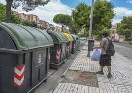 Un pacense se dirige a un contenedor de Valdepasillas con una bolsa de basura.