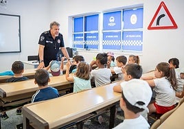 Un policía junto a alumnos del colegio Giner de los Ríos en el centro de educación vial.