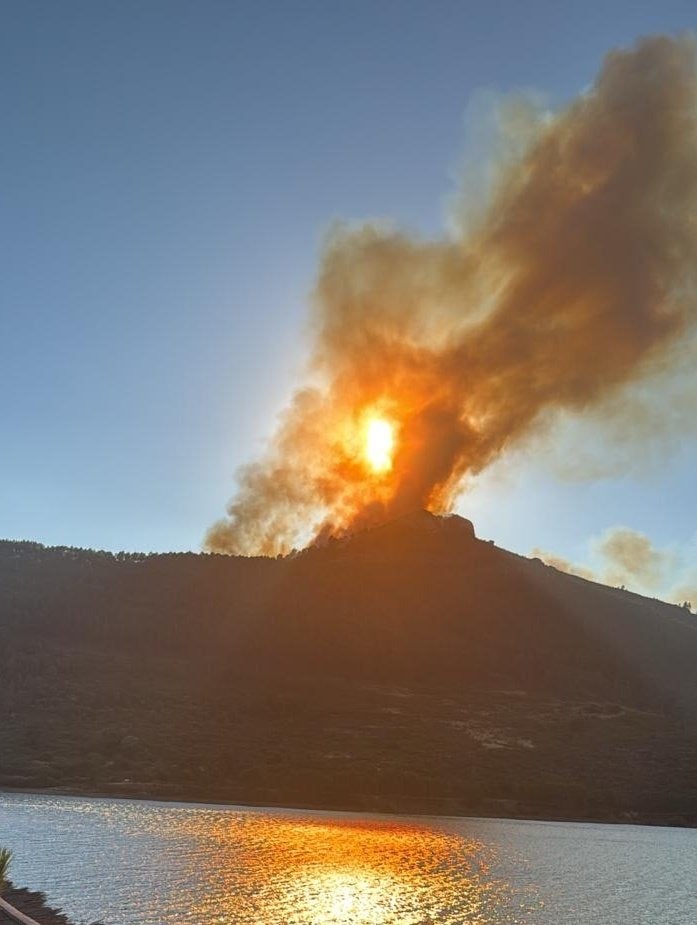 Llamas y columnas de humo provocadas por el incendio y vistas desde el embalse de Cancho del Fresno. Tarde del viernes