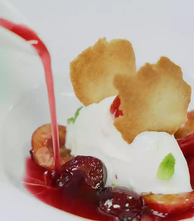 Infusión de cerezas del Jerte D.O.P. con helado de yogur, crujiente de almendras y hojas de menta