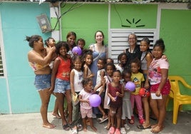 Divina Carrasco junto con niños beneficiado por los programas solidarios de la organización cacereña Personas.