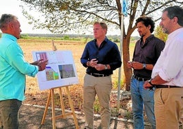 El alcalde comprueba los planos de las viviendas.