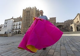 Emilio Rey posa con el capote delante de la Torre de Bujaco, en la Plaza Mayor de Cáceres.