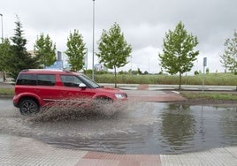 Un coche pasando por una balsa de agua en Badajoz.