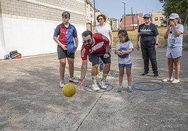 El monitor de la actividad enseña a los participantes cómo tienen que lanzar la pelota.