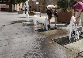 Imagen de archivo de dos jóvenes refrescándose en una fuente en Mérida.