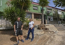 Saray Jorge y Jorge Regalado delante de su vivienda, en el talud de tierra que han limpiado.