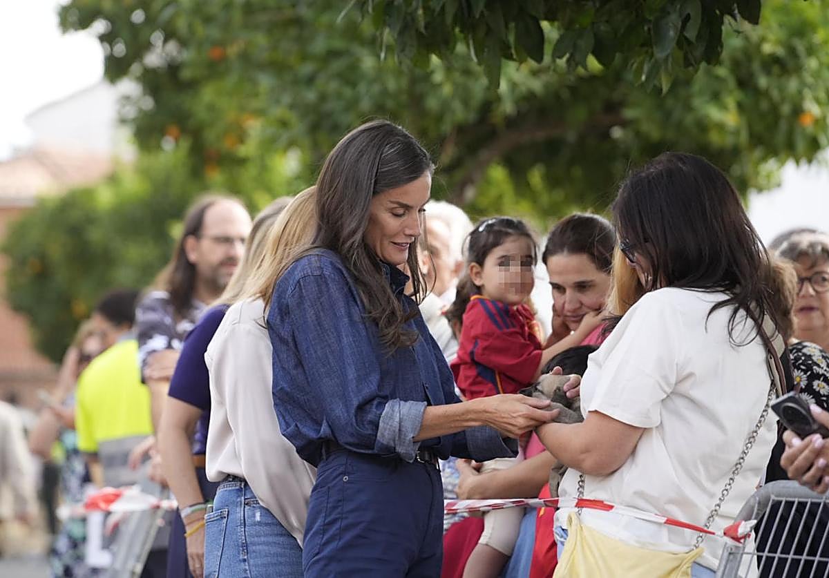 La Reina acaricia al perro 'Fuego'.
