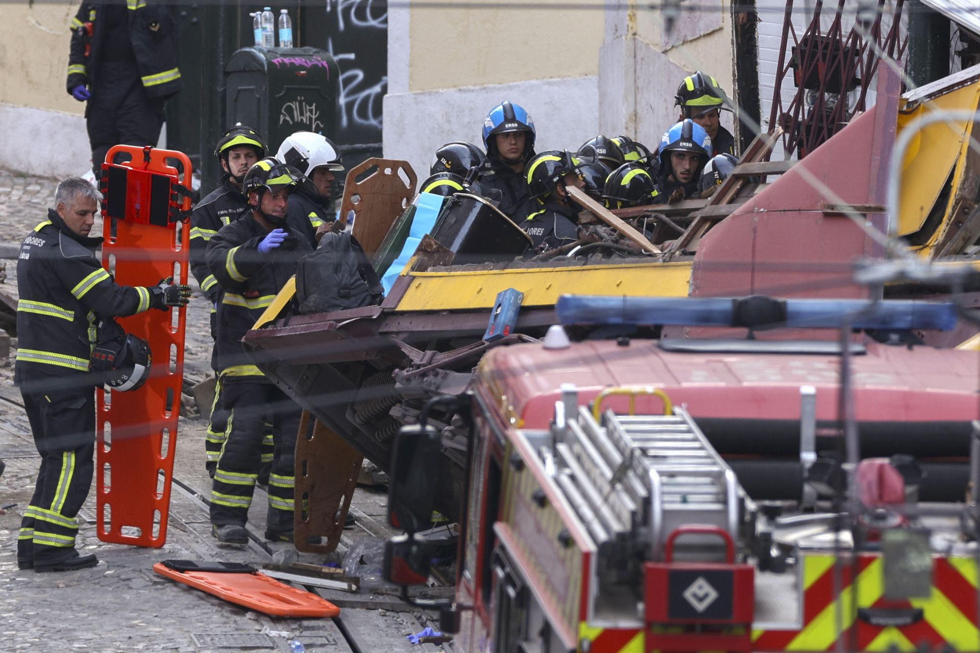 Bomberos y otros efectivos de rescate intentan sacar a las víctimas atrapadas tras el accidente del funicular de Gloria.