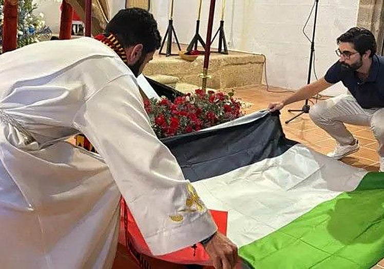 El padre Jonny durante la colocación de la bandera.