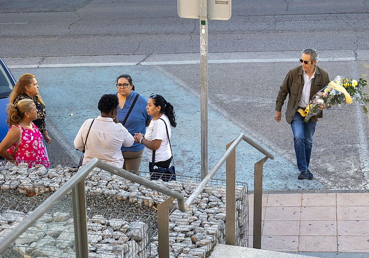 Francisco de Borja, presidente vecinal de La Madrila-Peña del Cura, llega este martes al tanatorio San Pedro de Alcántara con un ramo de flores para recordar a Jonathan. Pasa junto a un grupo de asistentes al velatorio.
