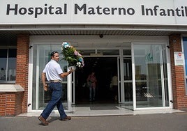 Un hombre entra en el Materno-Infantil de Badajoz con flores tras un parto.