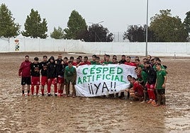 Jugadores del Barbaño y Badajoz B reivindican el césped artificial sobre el barrizal tras suspenderse el partido.