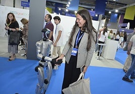 Una mujer saluda a un robot en la pertura del Congreso Potencial Digital 2025.