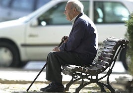Persona mayor sentada en un banco.