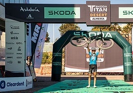 Natalia Fischer levanta su bici en señal de victoria al entrar en meta como vencedora incontestable de la Titán Desert Almería.