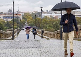 Un grupo de ciudadanos camina por el Puente Romano de Mérida en una jornada lluviosa de abril pasado.