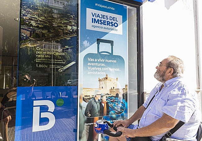 Una persona esta mañana ante un cartel de una agencia en la barriada de Valdepasillas de Badajoz.
