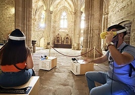 Dos turistas utilizan unas gafas de realidad virtual en la catedral de Plasencia.