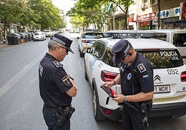 Dos agentes de Policía Local con el coche equipado para tramitar multas directamente en Badajoz.