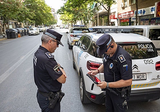 Dos agentes de Policía Local con el coche equipado para tramitar multas directamente en Badajoz.